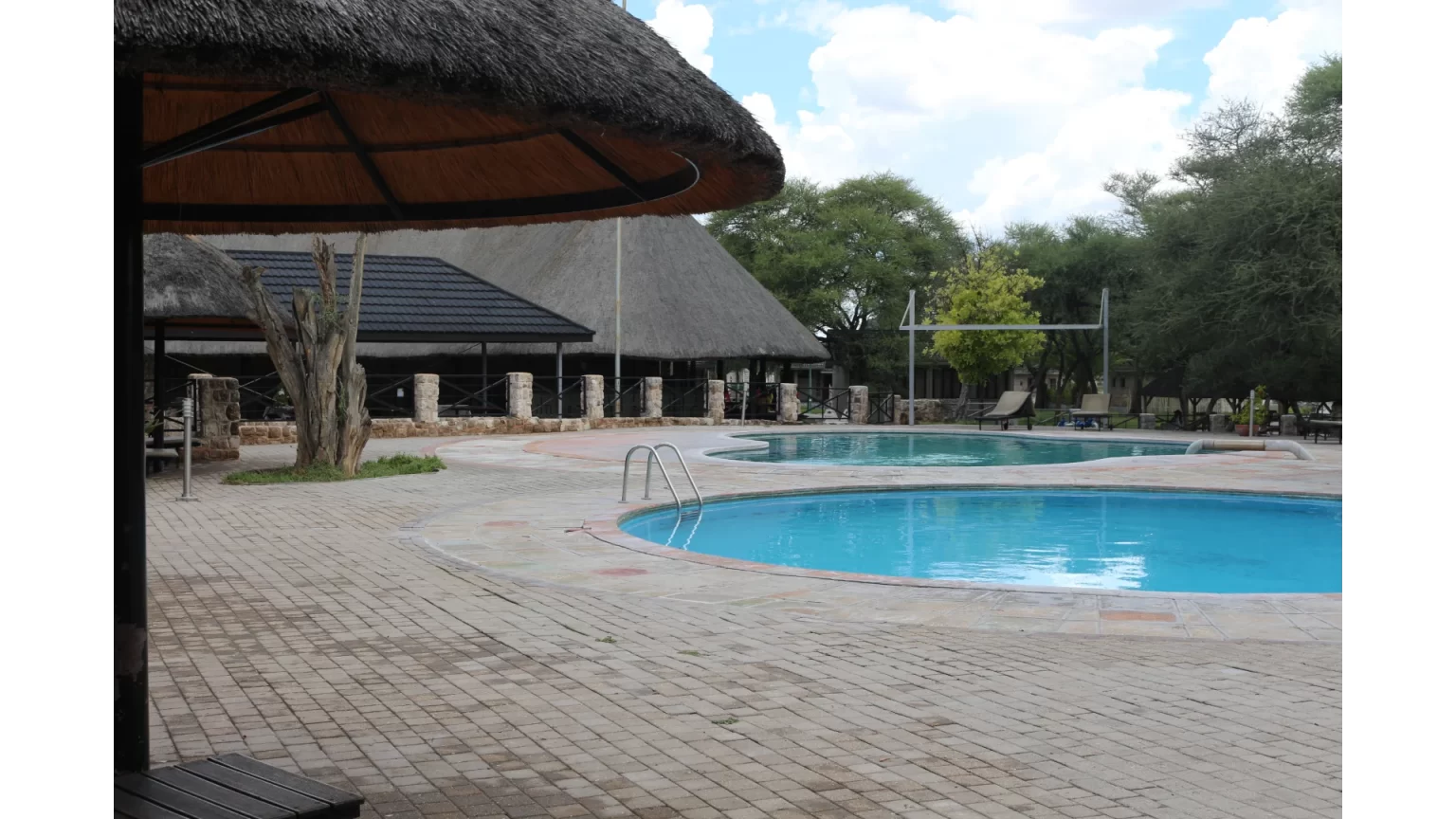 Swimming pool and thatched shade at Okaukuejo Camp