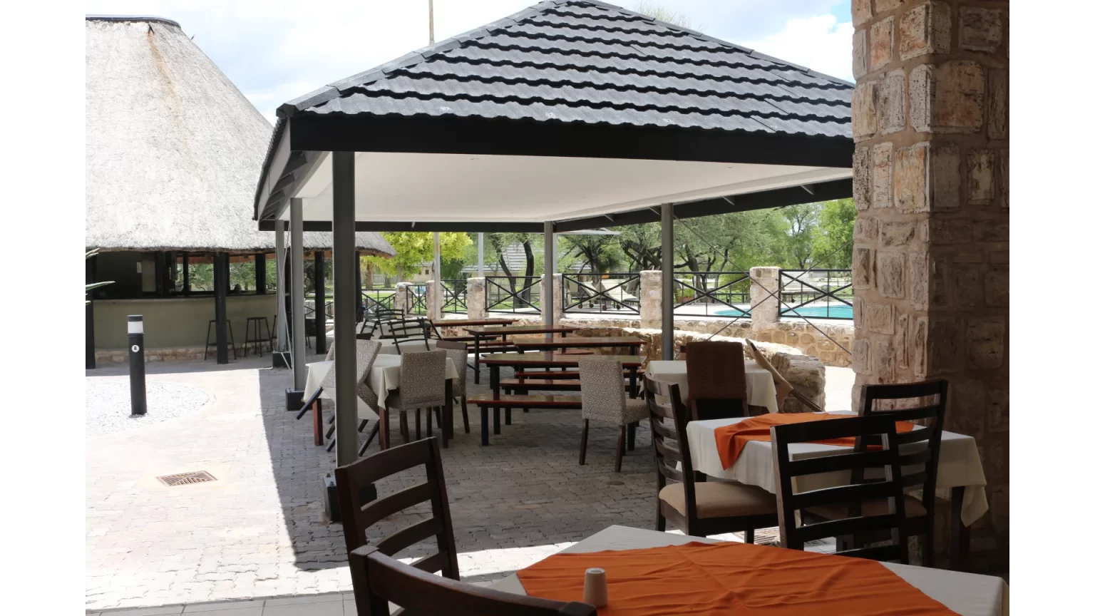 Poolside restaurant terrace with laid tables at Okaukuejo Camp