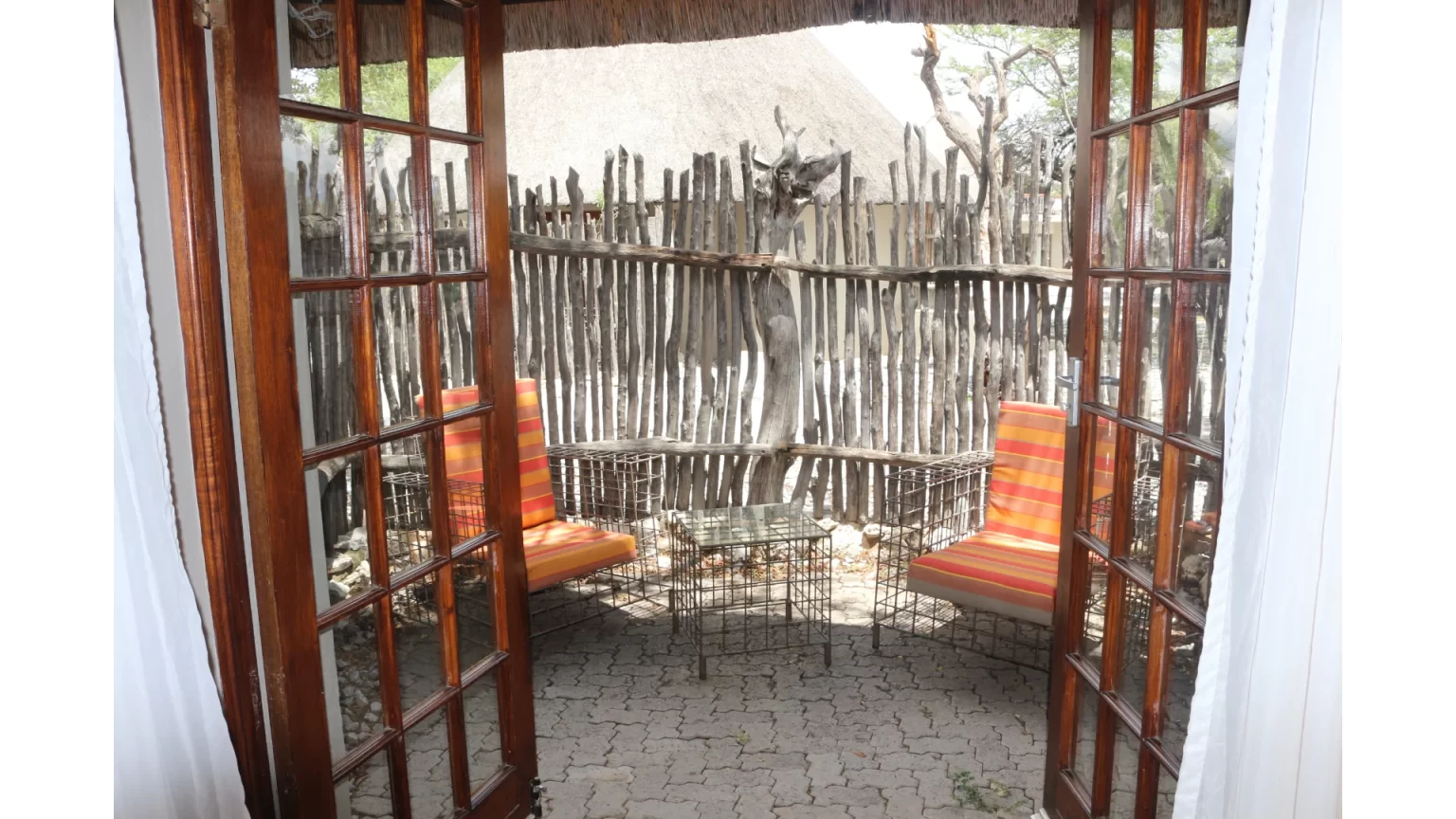 Private reed-screened patio with loungers at Okaukuejo Camp