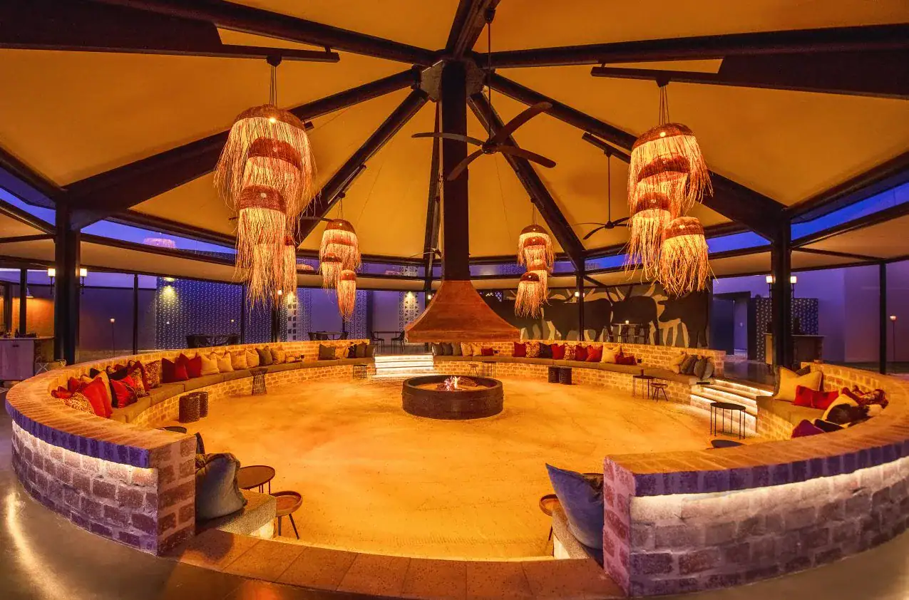 Etosha King Nehale Rates 2026 & Booking — Lodge at King Nehale Gate, Northern Etosha 8 Sunken fire-pit lounge with circular brick seating and woven lampshades at Etosha King Nehale