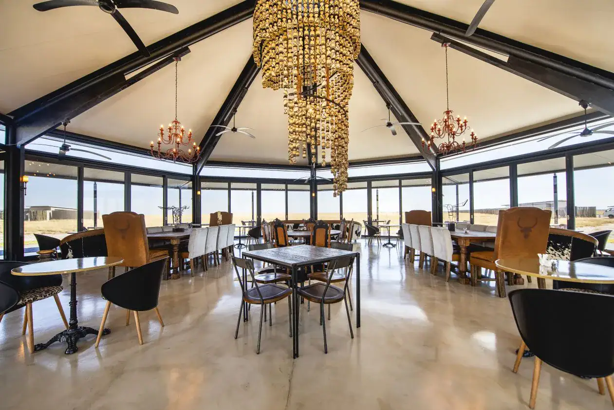 Etosha King Nehale Rates 2026 & Booking — Lodge at King Nehale Gate, Northern Etosha 5 Restaurant at Etosha King Nehale with golden beaded chandelier and panoramic savannah views