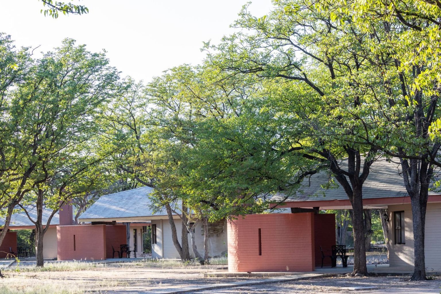 Exterior of a red-walled bush chalet at Halali Camp, Etosha