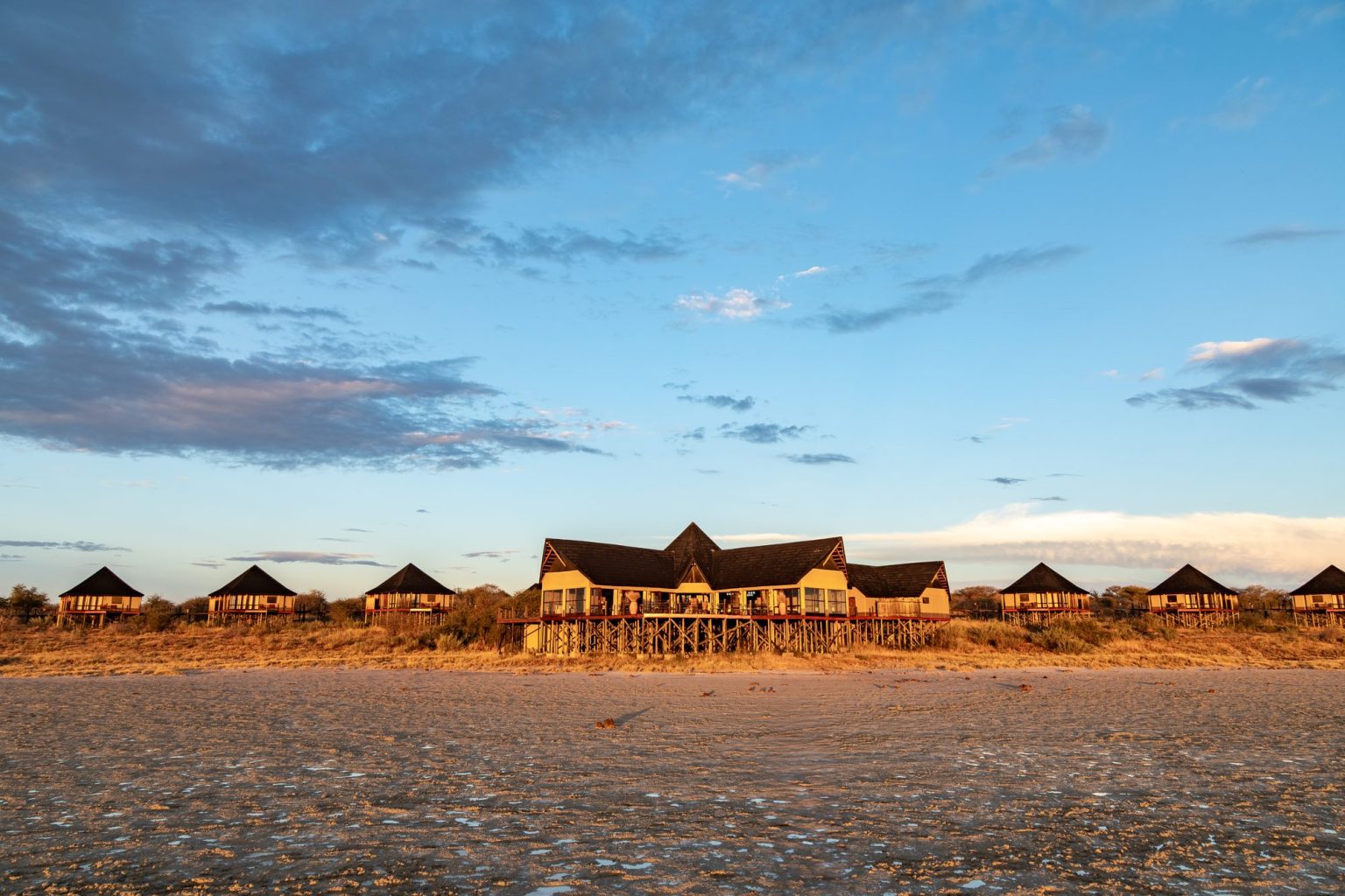 Onkoshi Camp chalets on stilts along the edge of the Etosha Pan