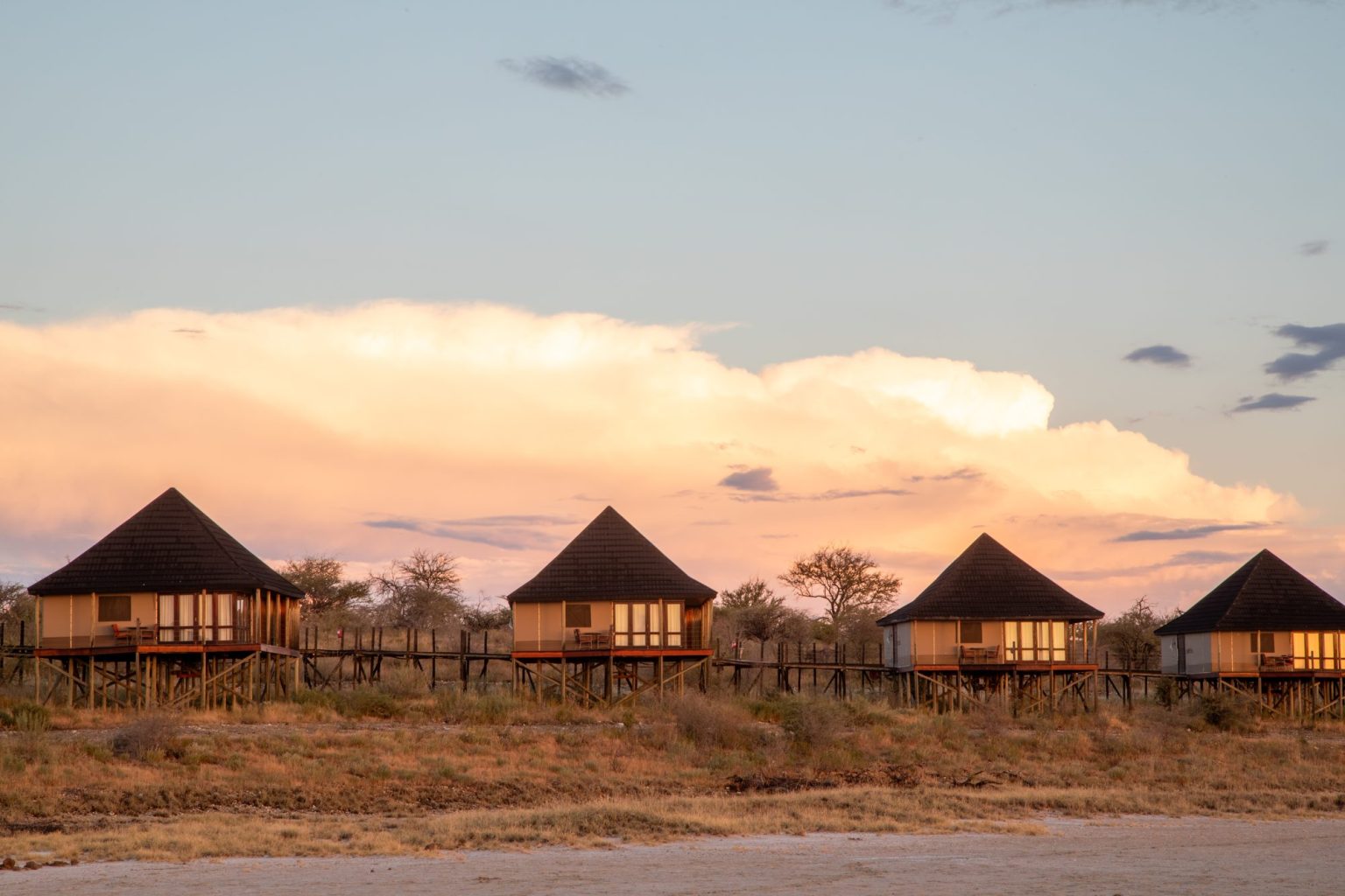 Onkoshi Camp chalets under sunset cloud over the Etosha Pan